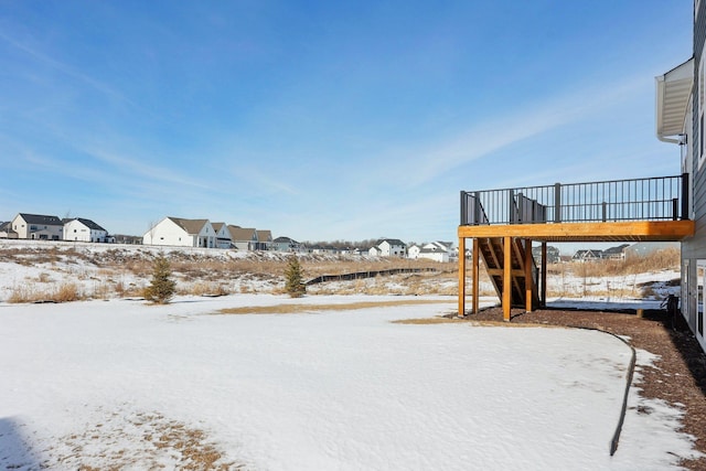 snowy yard with a residential view and a wooden deck