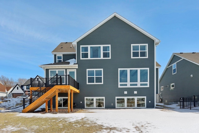 snow covered property featuring a wooden deck and stairs