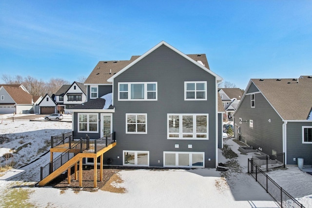 snow covered house with a residential view and stairs