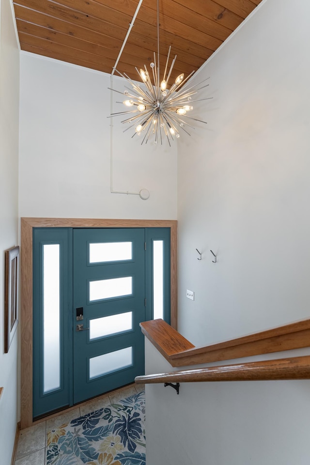 entrance foyer featuring wooden ceiling, a towering ceiling, light tile patterned flooring, and a notable chandelier