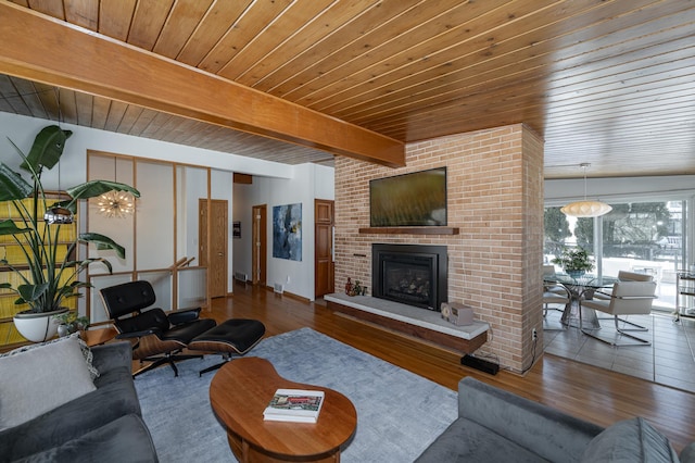 living area with wood ceiling, a brick fireplace, wood finished floors, and beam ceiling