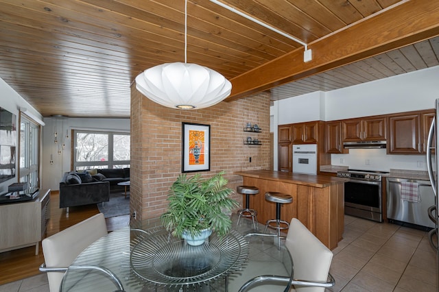 dining room with wood ceiling, light tile patterned floors, brick wall, and beam ceiling