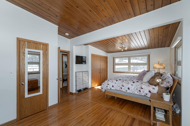 bedroom with lofted ceiling, wooden ceiling, and wood finished floors