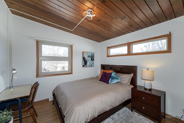 bedroom with vaulted ceiling, wood finished floors, and wood ceiling