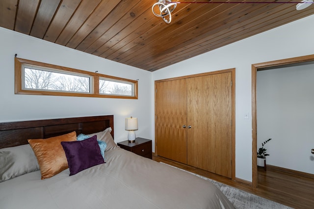 bedroom with a closet, wood ceiling, vaulted ceiling, and wood finished floors