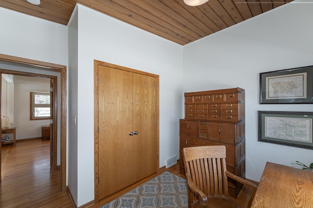 office space featuring wooden ceiling, baseboards, visible vents, and wood finished floors