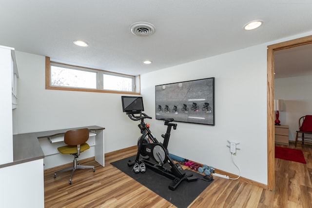 exercise area featuring recessed lighting, wood finished floors, visible vents, and baseboards