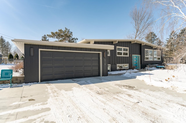 view of front of property featuring an attached garage, fence, and board and batten siding