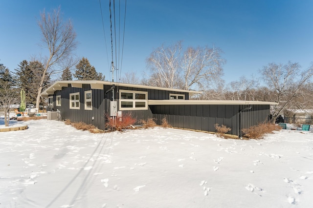 snow covered house with board and batten siding