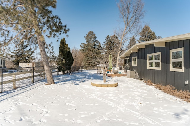 snowy yard featuring fence