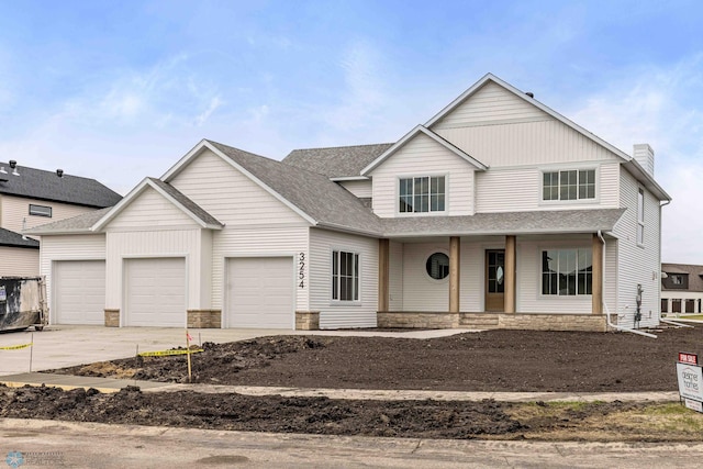 3254 Timber Creek Cir S, Fargo, ND 58104 - view of front of house featuring concrete driveway, an attached garage, covered porch, and stone siding