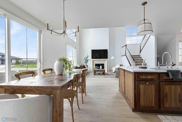 3254 Timber Creek Cir S, Fargo, ND 58104 - dining room featuring a chandelier, light wood-style floors, stairs, and a fireplace