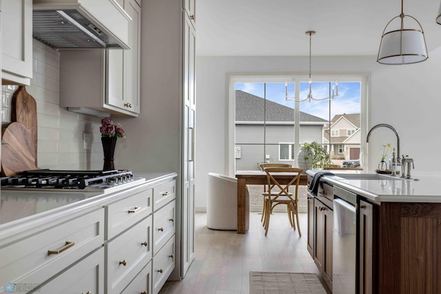 3254 Timber Creek Cir S, Fargo, ND 58104 - kitchen with custom range hood, stainless steel appliances, tasteful backsplash, light countertops, and light wood-style flooring