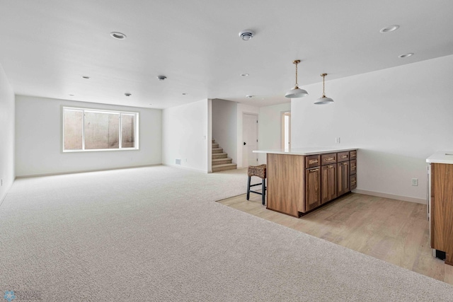 3254 Timber Creek Cir S, Fargo, ND 58104 - kitchen with brown cabinetry, open floor plan, a breakfast bar area, decorative light fixtures, and baseboards