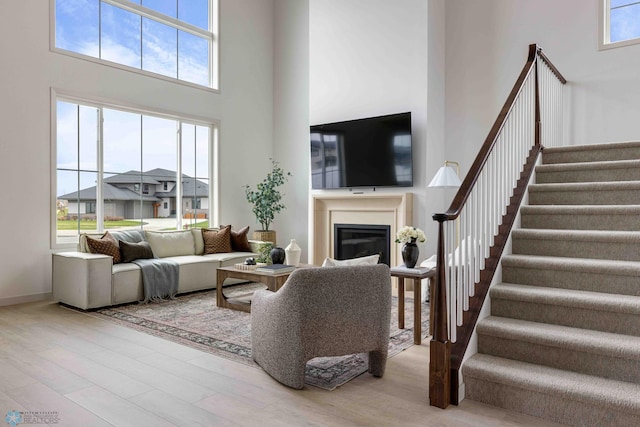 3254 Timber Creek Cir S, Fargo, ND 58104 - living area with a high ceiling, stairway, wood finished floors, and a glass covered fireplace