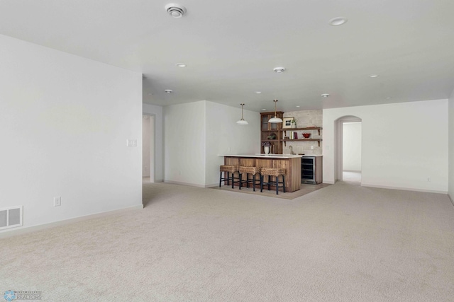 3254 Timber Creek Cir S, Fargo, ND 58104 - unfurnished living room with arched walkways, light colored carpet, baseboards, recessed lighting, and bar area