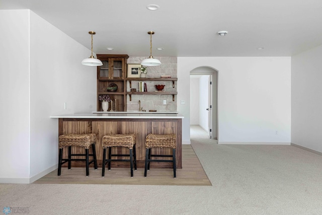 3254 Timber Creek Cir S, Fargo, ND 58104 - indoor dry bar with arched walkways, light colored carpet, hanging light fixtures, baseboards, and recessed lighting