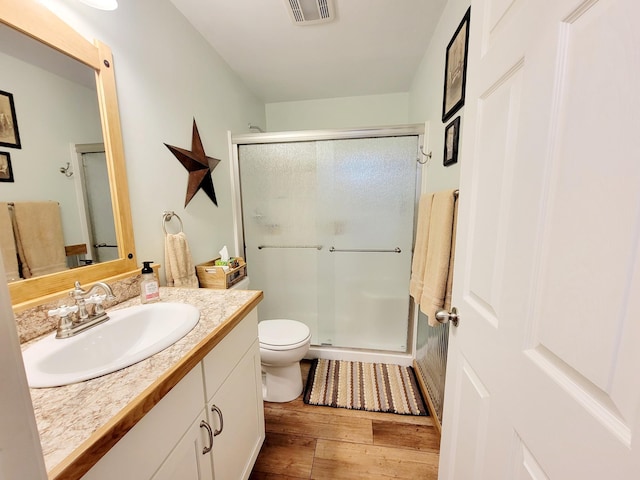 409 Hummingbird Ln, New York Mills, MN 56567 - bathroom featuring wood finished floors, visible vents, vanity, and a stall shower