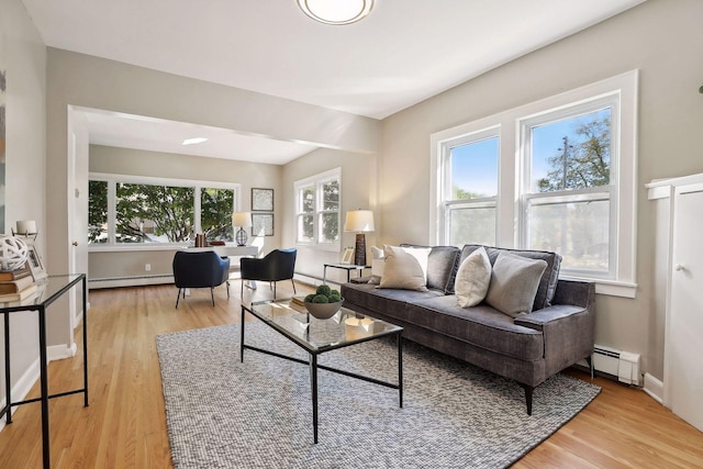 living room with baseboard heating, light wood-type flooring, and baseboards