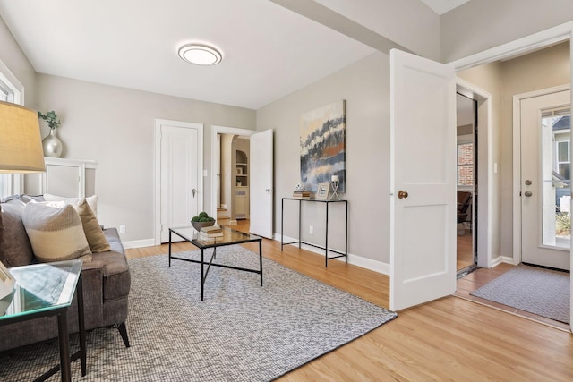 interior space with plenty of natural light, baseboards, and wood finished floors