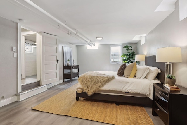 bedroom with baseboards and wood finished floors