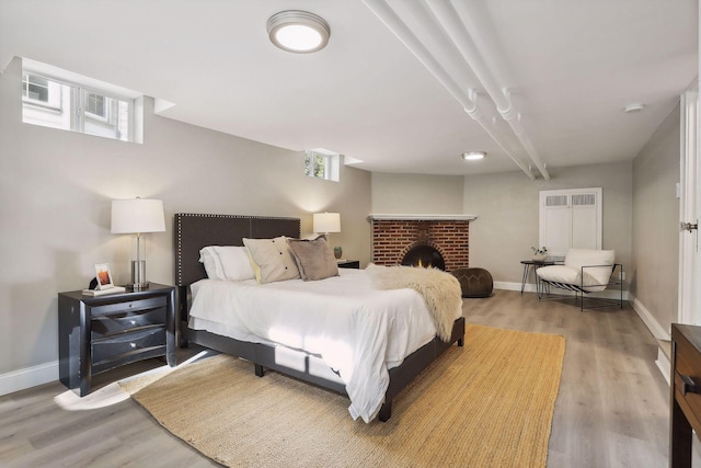 bedroom featuring baseboards, multiple windows, and light wood-style floors