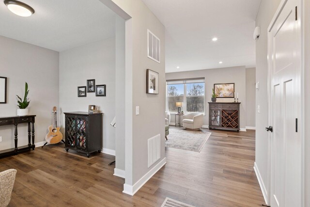 corridor with visible vents, baseboards, recessed lighting, and wood finished floors