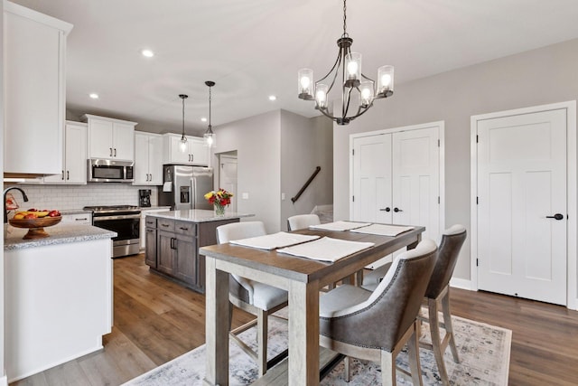 dining area with recessed lighting, a chandelier, stairway, and dark wood finished floors