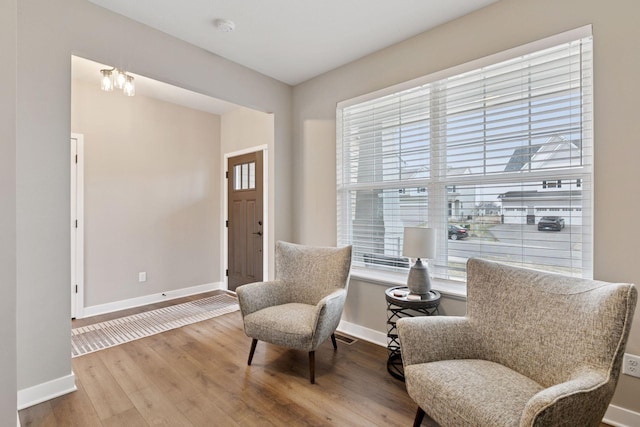 living area featuring visible vents, baseboards, and wood finished floors