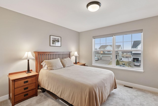 bedroom featuring light carpet, visible vents, and baseboards