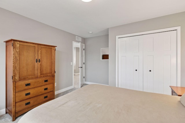 bedroom with visible vents, baseboards, a closet, and light colored carpet