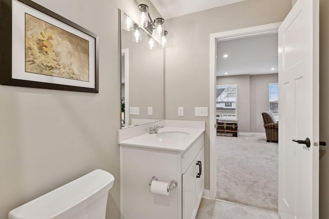 bathroom with recessed lighting, vanity, baseboards, and toilet