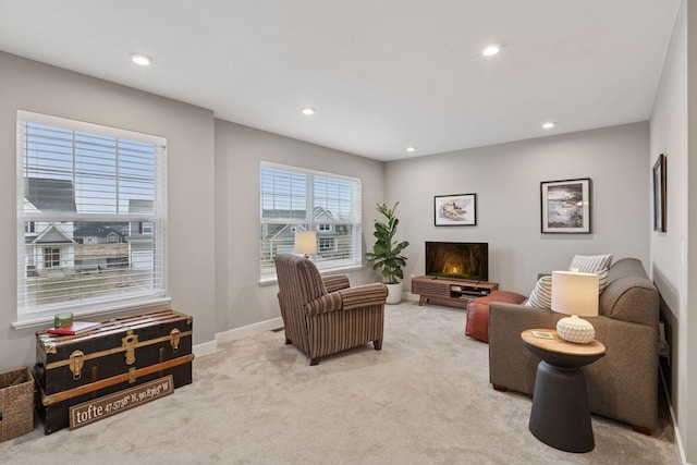 living area featuring light colored carpet, baseboards, and recessed lighting
