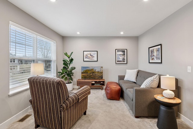 living area featuring light colored carpet, baseboards, visible vents, and recessed lighting