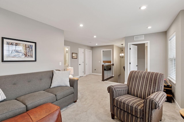 living room featuring recessed lighting, visible vents, light colored carpet, and baseboards