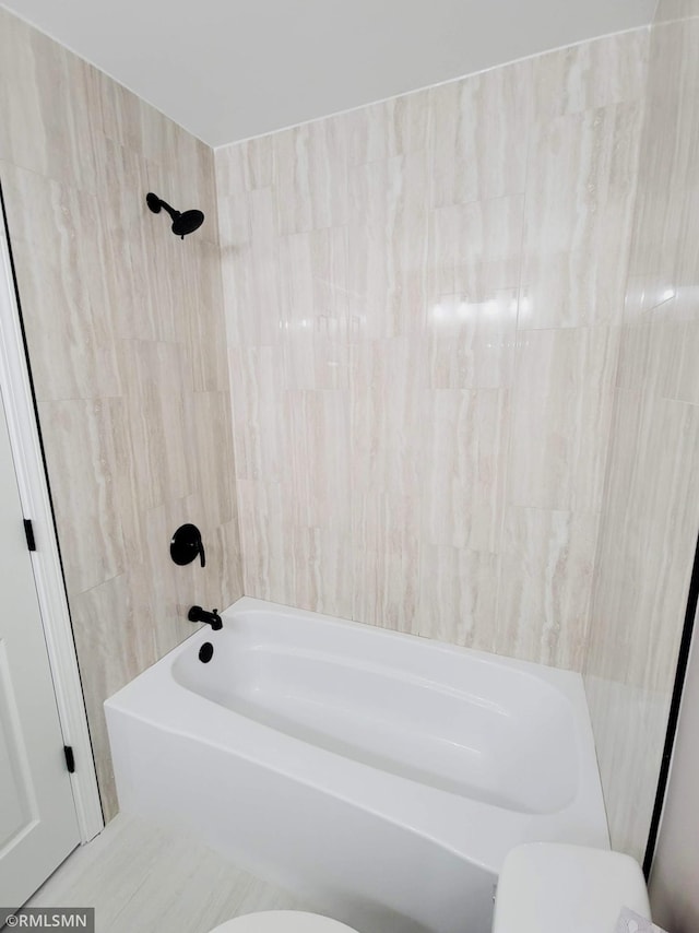 bathroom with shower / washtub combination and toilet