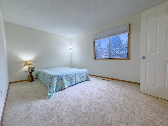 bedroom featuring carpet, visible vents, baseboards, and a textured ceiling