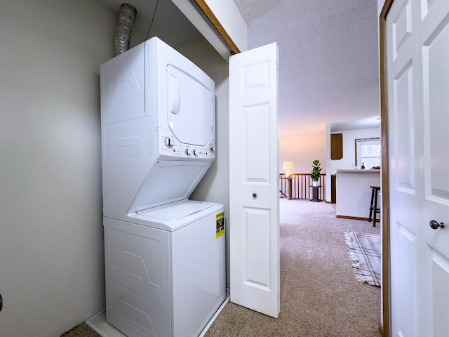 washroom with carpet, laundry area, a textured ceiling, and stacked washing maching and dryer