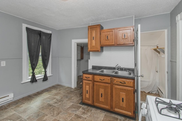 kitchen with a baseboard radiator, white range, a sink, brown cabinets, and dark countertops