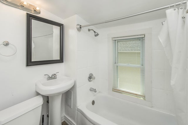 full bath featuring a wealth of natural light, shower / bath combo with shower curtain, and toilet