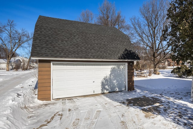 snow covered garage featuring a detached garage