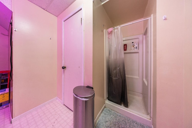 full bathroom with a shower stall, baseboards, and tile patterned floors