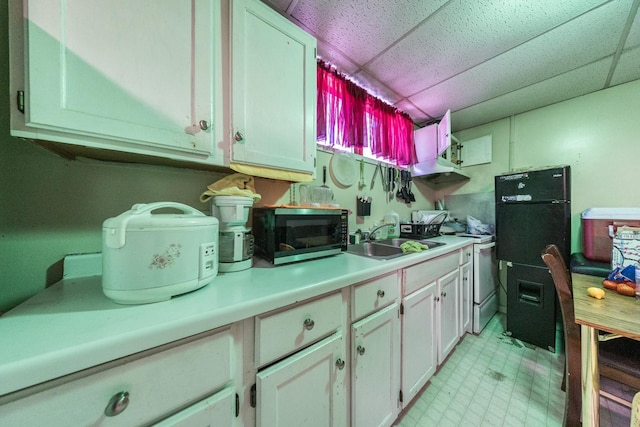 kitchen with light floors, white gas range, light countertops, a sink, and a drop ceiling