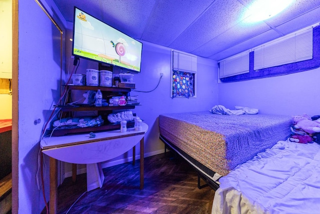 bedroom featuring wood finished floors and baseboards