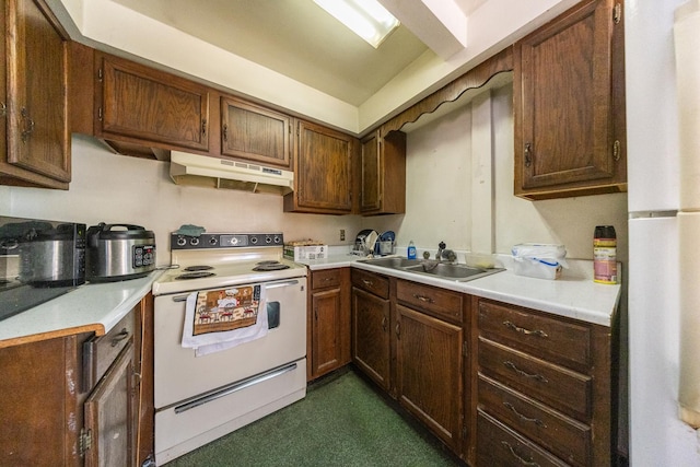 kitchen featuring white appliances, light countertops, a sink, and under cabinet range hood