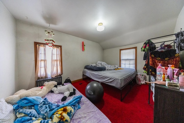 carpeted bedroom with vaulted ceiling and radiator