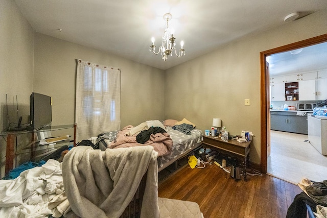 bedroom with a chandelier and wood finished floors