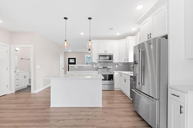 585 Cedar Dr, Lake City, MN 55041 - kitchen featuring stainless steel appliances, light countertops, white cabinetry, decorative backsplash, and light wood finished floors