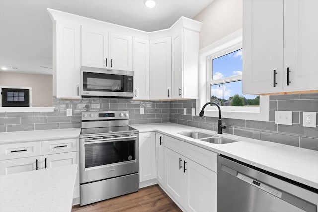 585 Cedar Dr, Lake City, MN 55041 - kitchen with appliances with stainless steel finishes, tasteful backsplash, white cabinets, light stone counters, and dark wood-style floors