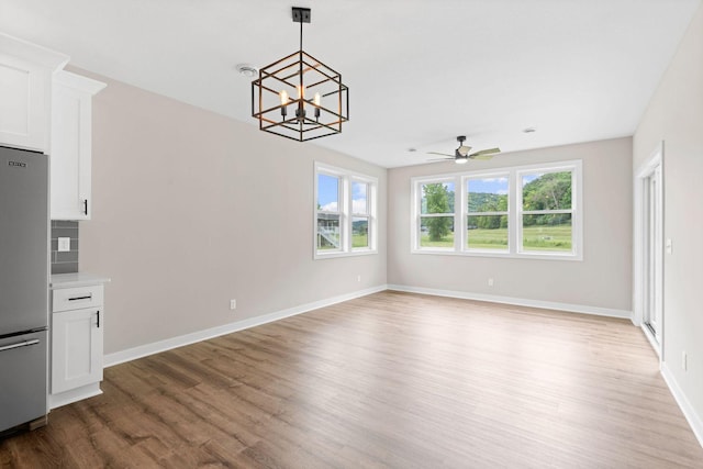 585 Cedar Dr, Lake City, MN 55041 - unfurnished dining area with wood finished floors, ceiling fan, and a chandelier